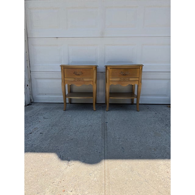 We have a beautiful pair of vintage French Provincial nightstands for sale. They feature an antiqued gold finish, curved...