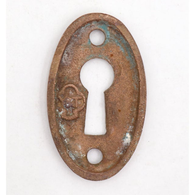 Vintage Classic style oval shaped keyhole cover plate made of brass with an antique brass finish. Made by Yale & Towne....