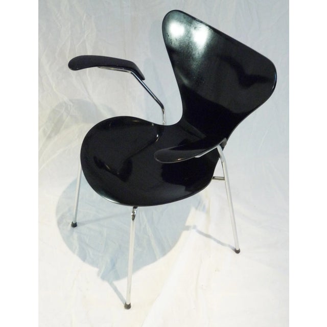 Model 3207 chair with armrests designed by Arne Jacobsen. This version features a matte black shell and glossy black...