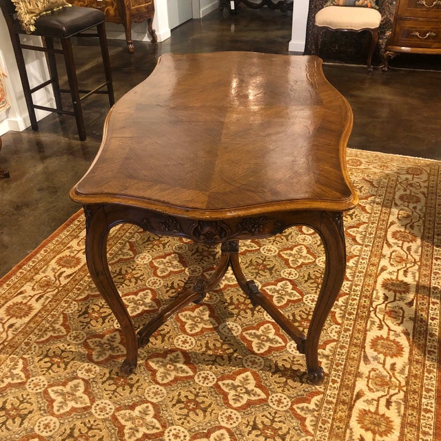 Antique hand-carved and shaped center table with book matched walnut top. The beautifully carved apron features a drawer...