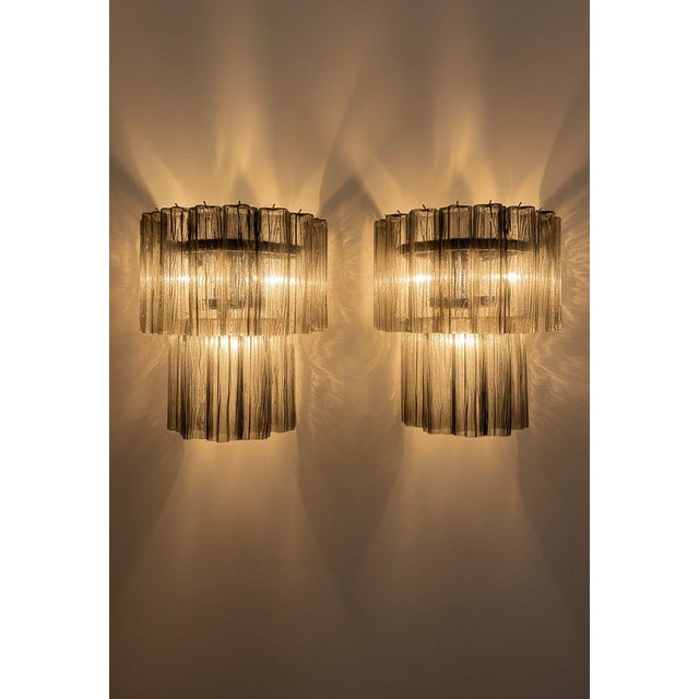 DUTIES FREE An exceptional pair of Italian Murano glass wall sconces featuring a striking starburst composition of...