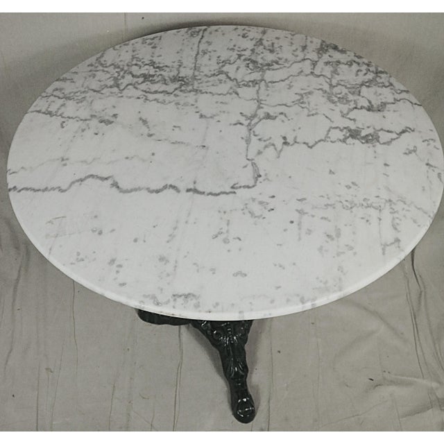 A late 19th century French garden table with a cast iron base and a marble top. The base has been cleaned and newly...