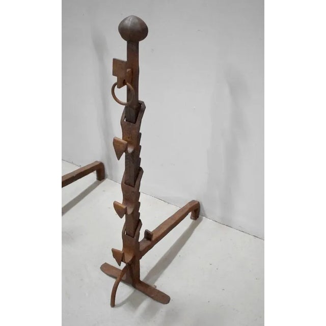 Pair of large andirons wrought iron. andirons heads are notched at the back and ornamented with curved parts on the front....