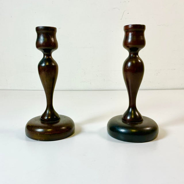 This pair of Early 20th Century hand-turned wood Candle Holders are a part of Americana. They are walnut and feature a...