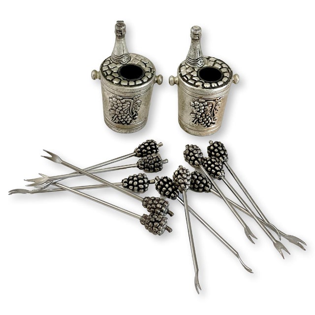 A finely detailed Spanish pewter hors d’oeuvre pick set featuring eleven cocktail picks and two coordinating holders. The...