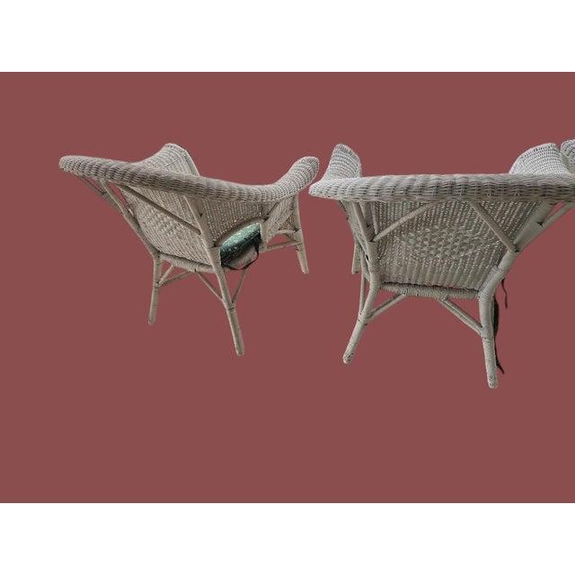 Bring timeless coastal charm to your sunroom, covered porch, or patio with this vintage white wicker conversation set....