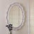Oval wall mirror with wavy ceramic frame. Handmade in Los Angeles. Includes attached mounting bracket for installation....
