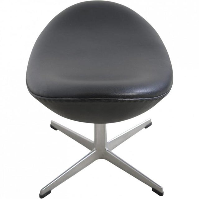 Arne Jacobsen Egg stool upholstered in original black aura leather, and with a base of brushed aluminium. The stool is...