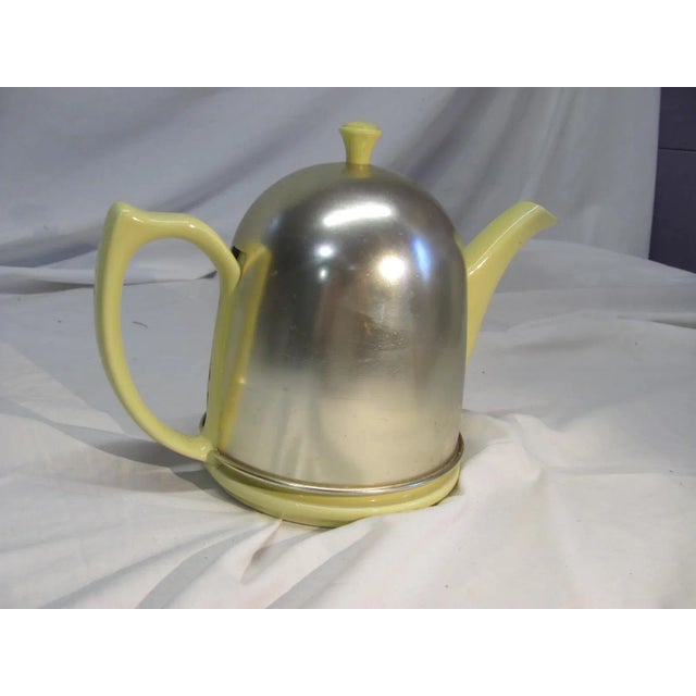 Lovely HALL Teapot with felt lined aluminum cozy. The ceramic glaze is a pale yellow. The aluminum cozy with matching...