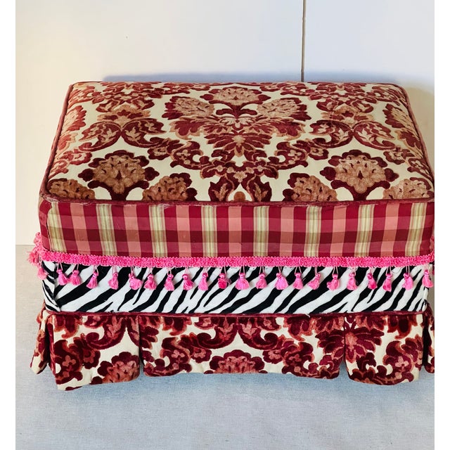 Colourful vintage ottoman footstool in burgundy red cut velvet and pink fringes in Mackenzie Childs style.