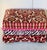 Colourful vintage ottoman footstool in burgundy red cut velvet and pink fringes in Mackenzie Childs style.