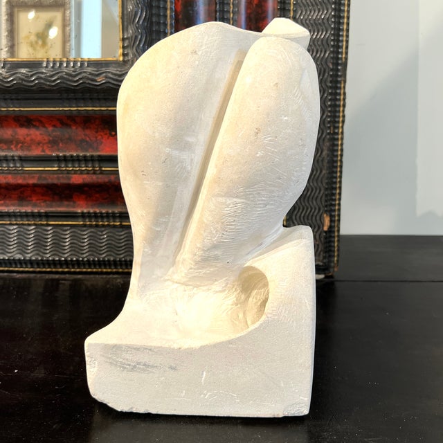 A striking mid-century contemporary stone sculpture with abstract, organic form and hand-carved texture—blending modernist...