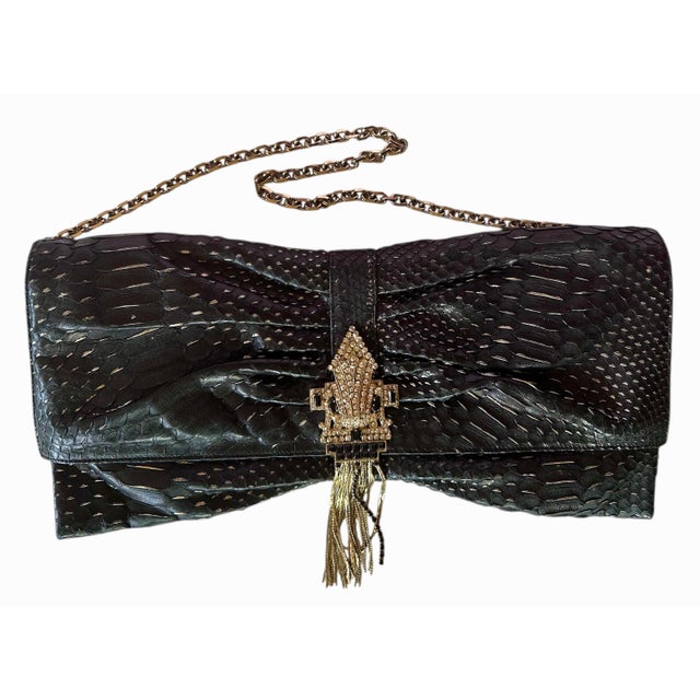 This stylish ruched snake skin bag with gold flecks features an art deco inspired crystal studded clasp ending in a...