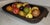 This 19thc wood dough bowl with a collection of 24 pcs. of stone fruit or alabaster fruit.This collection includes the...