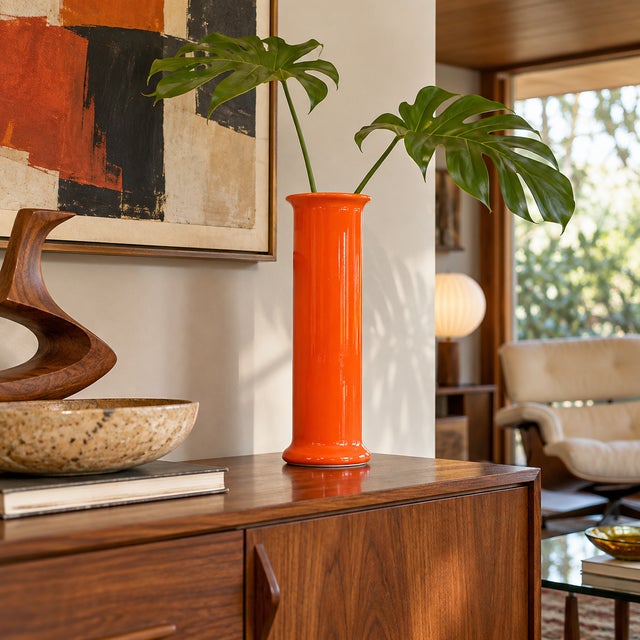 Striking Italian ceramic cylinder vase featuring a vivid glossy orange glaze and a clean, elongated modernist form. The...