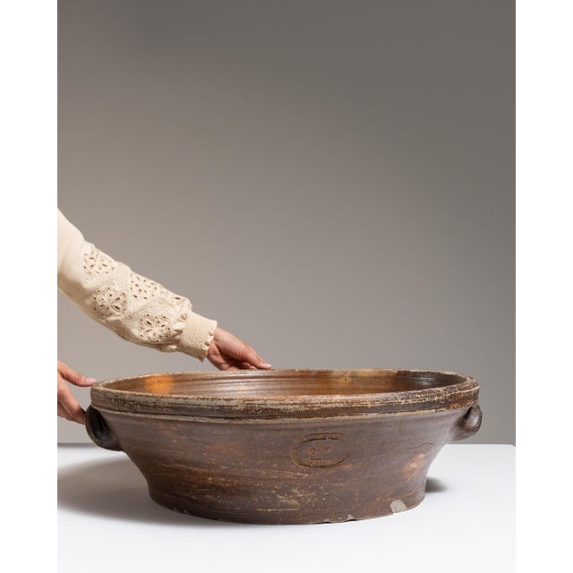 This early 20th century serving bowl from France is finished in chocolate, worked in ceramic. Its form follows honest,...