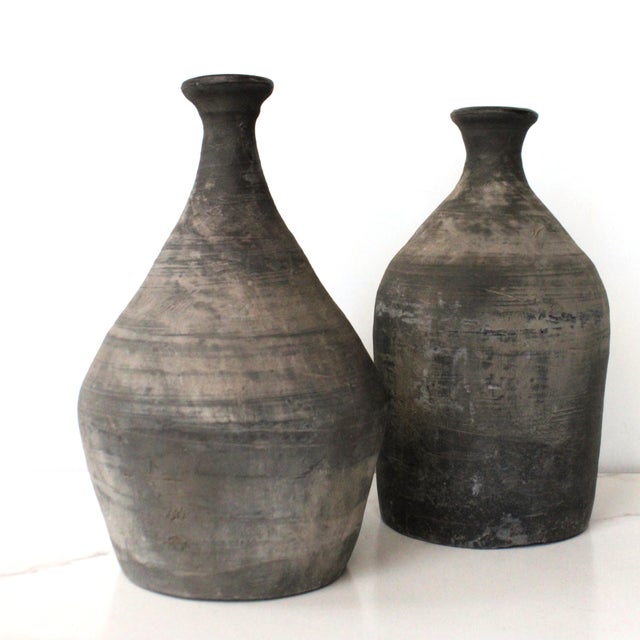 Weathered antique handcrafted clay jug vase. Hand-thrown vases were made and shaped by hand and fired in a wood-burning...