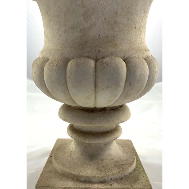 A pair of Carrara marble Campana shaped garden urns, 19th century. Each decorated with a continuous band of lobes. On...