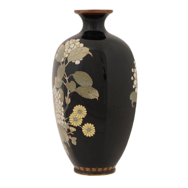 An antique Japanese brass and Cloisonne enamel vase. The baluster shaped vase with octagonal black body is enameled with a...