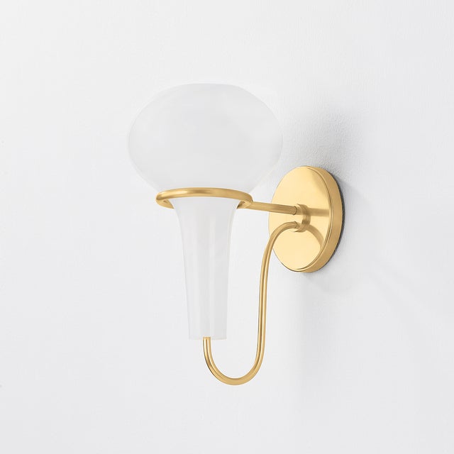 A delicate metal framework supports the upside-down, pear-shaped shade of the Adams Corner sconce. Adding a surprising...