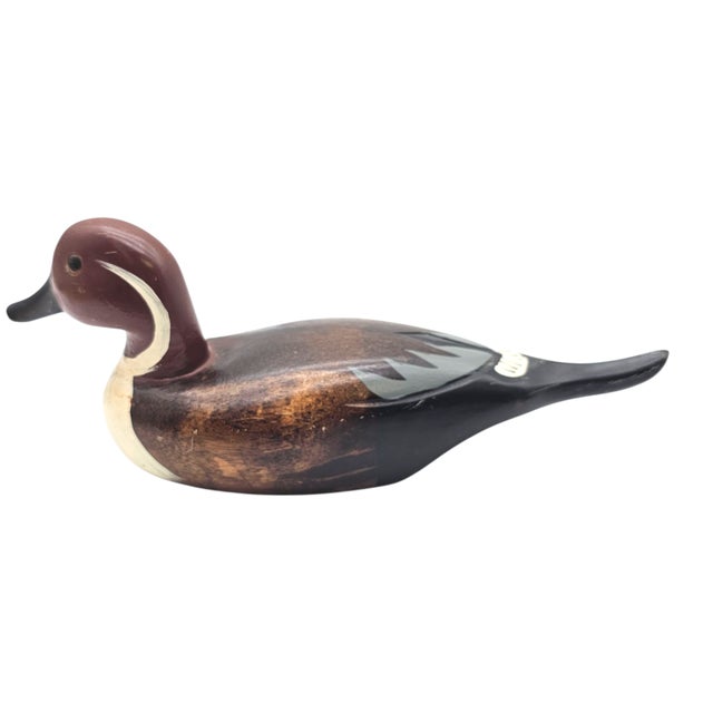 A quiet drifter from the marshlands of memory, this hand-carved fellow glides across the shelf with glass eyes that know...