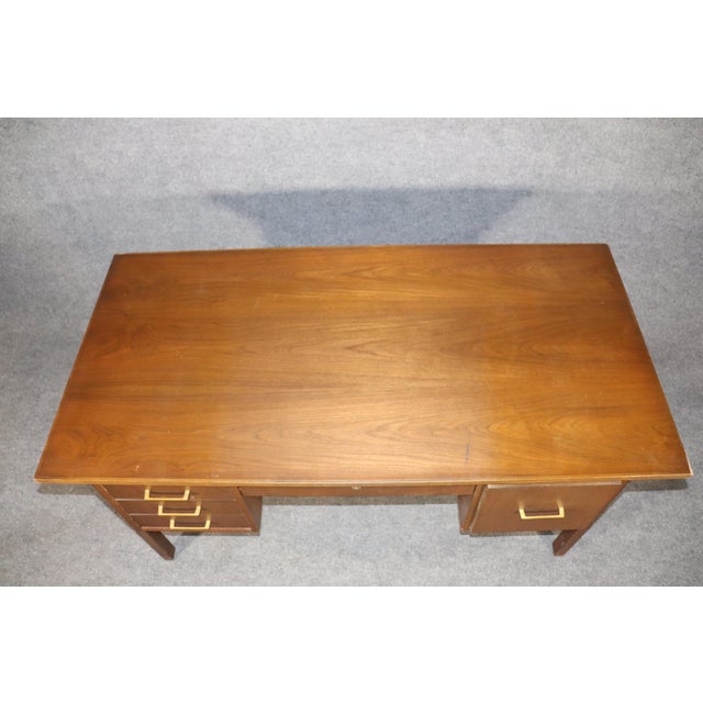 Mid-Century Modern desk made by the Indiana Desk Company. Large walnut desktop and five drawers with brass handles.