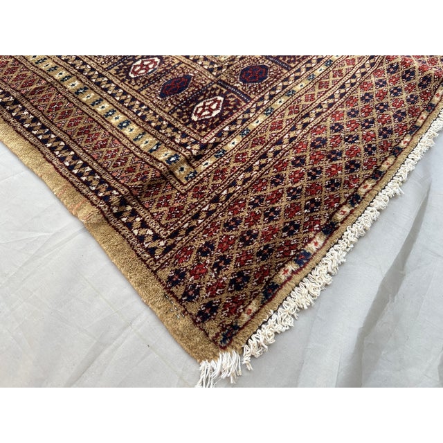 This elegant vintage Pakistani rug, hand-knotted in the 1980s, is a fine example of traditional tribal craftsmanship. Its...