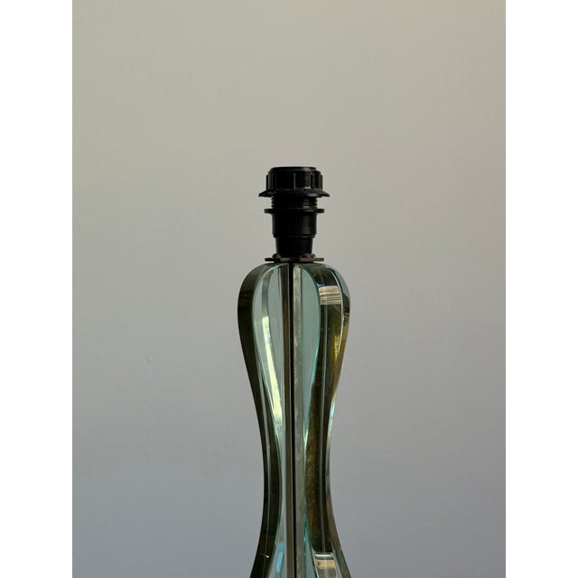 A mid century glass table lamp attributed to Fontana Arte. Comprised of graphic glass pieces and brass hardware. Sourced...