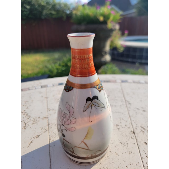 A beautifully porcelain vase featuring blossoming branches, songbirds, and butterflies, executed in fine linework with...