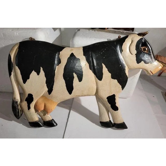 This hand carved & painted folky cow wood hanging double sided trade sign.This carved cow has the original metal chain and...