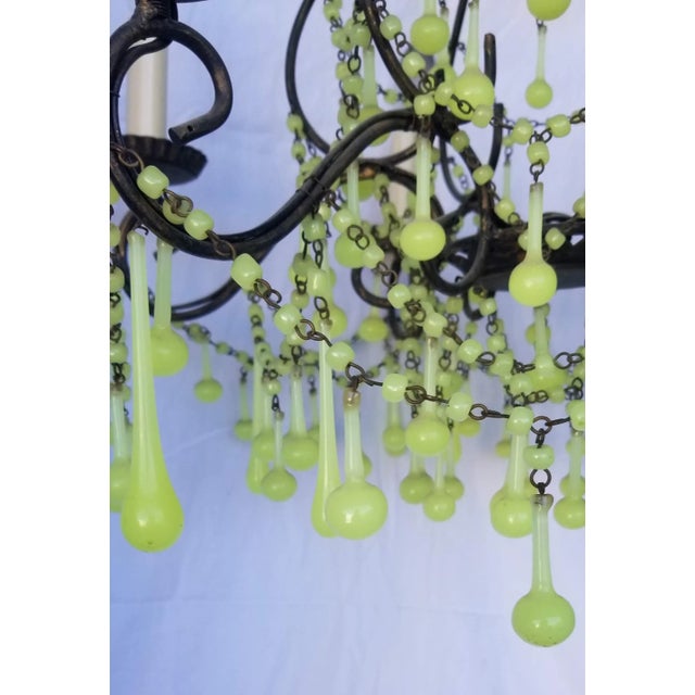 Metal body with swags of green opaline or Vaseline glass. Rewired in working condition and ready to hang.