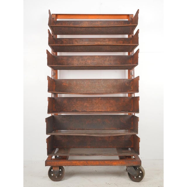 Industrial style orange painted steel rolling cart featuring seven adjustable, removable tray style shelves. Good...