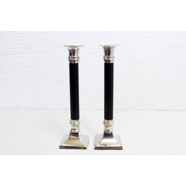 Pair of black metal and silver metal candlesticks, 1960 with a timeless design, this duo of candlesticks from the 60s/70s...
