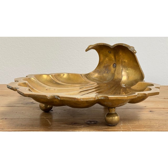 Oversized vintage brass shell dish with shell motif to bowl. Three exaggerated ball feet give this piece substantial...