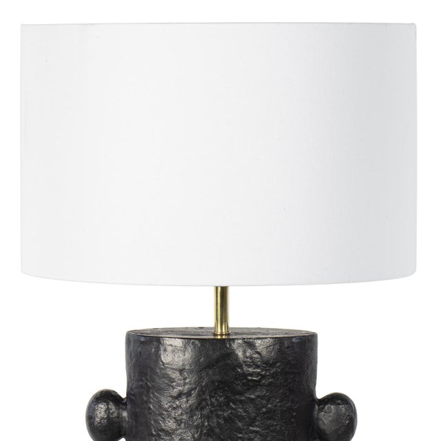 The Maya Table Lamp is rich with primitive, sculptural beauty. Maya's cast metal body and paper maché finish is the...