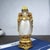 This is a vintage snuff bottle crafted from frosted glass and adorned with gilt metal overlay. The design features two...
