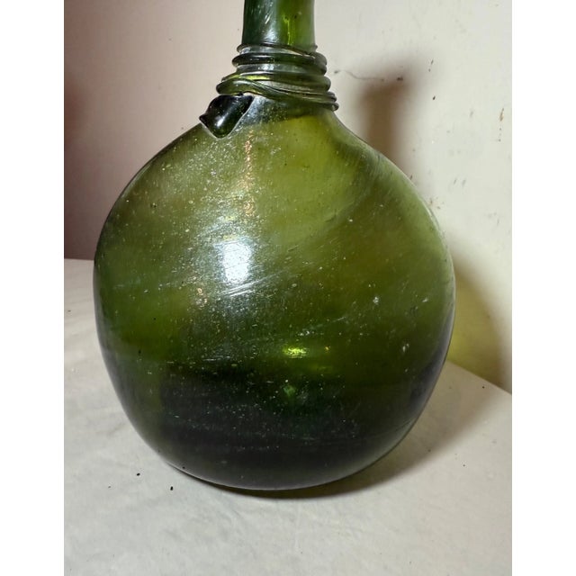 This rare antique flask is a very unique piece of Middle Eastern history. The hand blown green glass, lovely silhouette,...