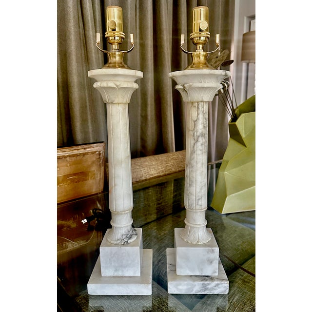 Pair of neoclassical style carved column form alabaster table lamps. Lots of nice natural viewing throughout. Newly wired...