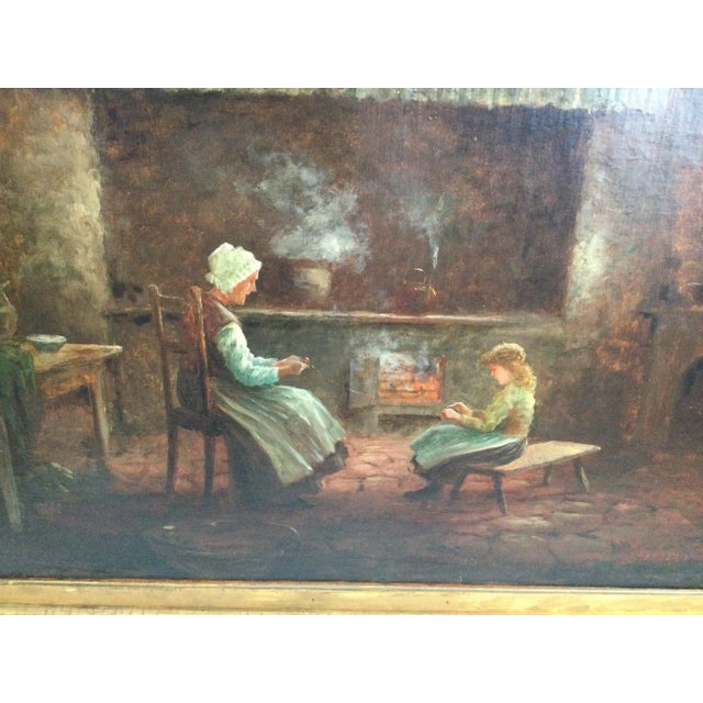 A large oil painting on canvas of an interior scene of mother and daughter in front of a fireplace doing needlework. The...