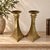 A striking pair of vintage brass candlesticks with bold architectural lines and dramatic four-point geometric bases. Made...