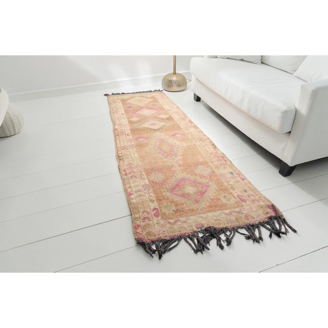 This is a vintage Turkish Oushak rug from the Mid 20th Century. The piece was hand-knotted.