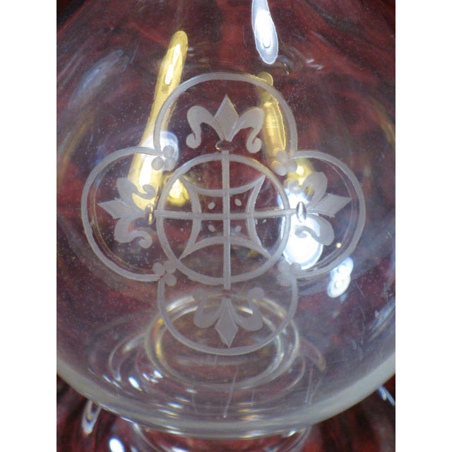 The product is an antique glass pitcher from the 1860s, hand-blown and featuring intricate Fleur de Lis engraving. This...