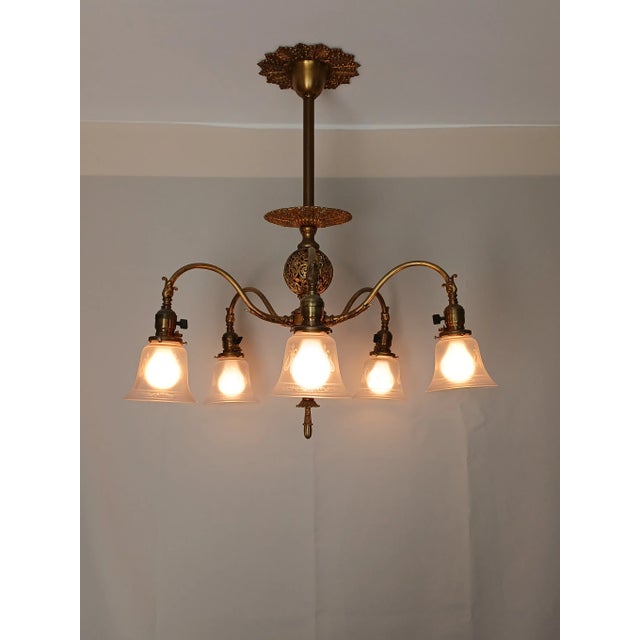 Exquisite antique 5-armed brass chandelier. Fluted brass column with filigree and textured brass globes and filigree pans....