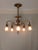 Exquisite antique 5-armed brass chandelier. Fluted brass column with filigree and textured brass globes and filigree pans....