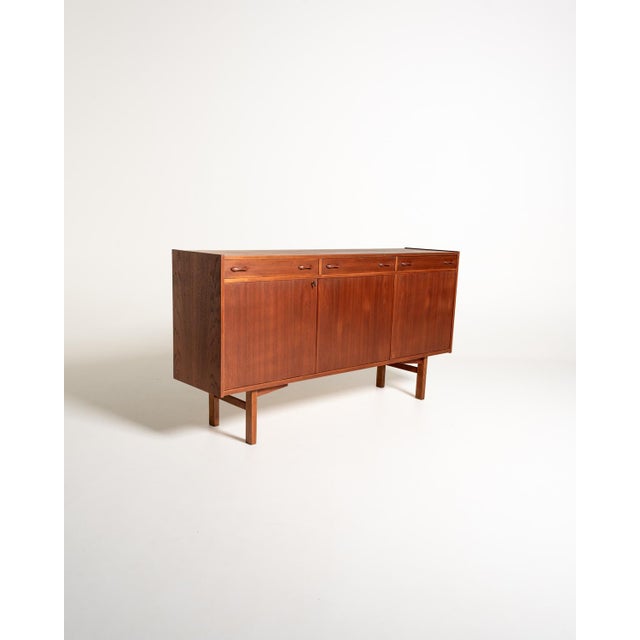 Sideboard designed by Tage Olofsson for Ulferts in the 1960s, featuring a rectangular teak frame supported by two wooden...