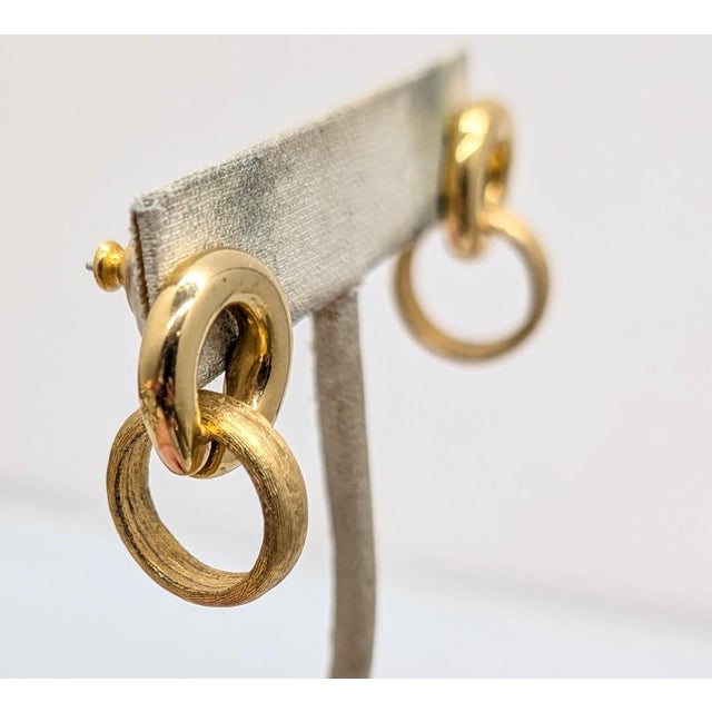 1980s goldtone smooth loop top with textured loop drop pierced push back earrings. Marked "GIVENCHY©" on the back of both...