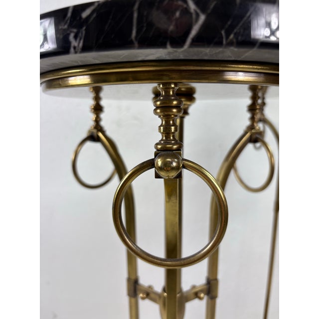 This is a pair of antique early 20th century marble topped pedestal tables. These incredible pedestals feature black...