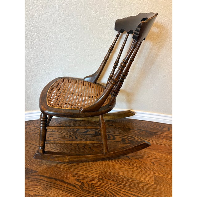A delightful example of late Victorian craftsmanship, this petite antique rocking chair, circa 1880–1900, combines...
