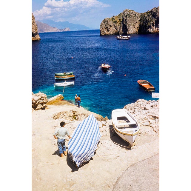 Capri Boats by Toni Frissell A Riva motorboat approaches a Capri dock with a yacht behind it and surrounded by various...