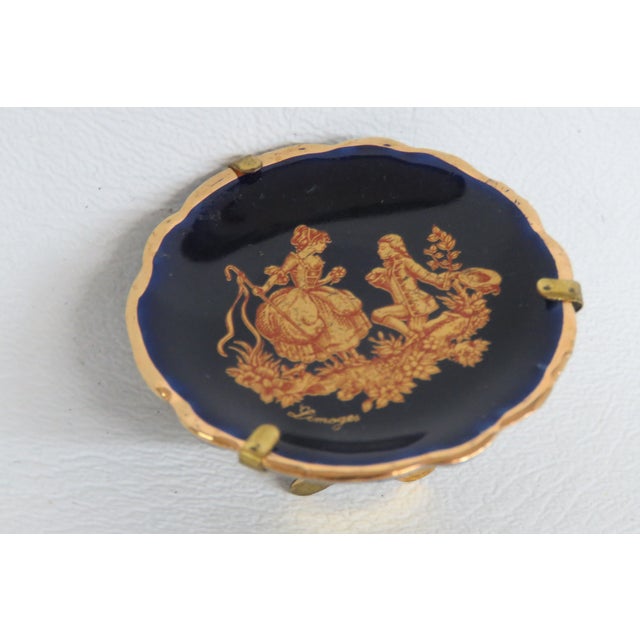 This lovely miniature plate is made of Porcelain and comes with a metal stand. This dainty porcelain collectible features...